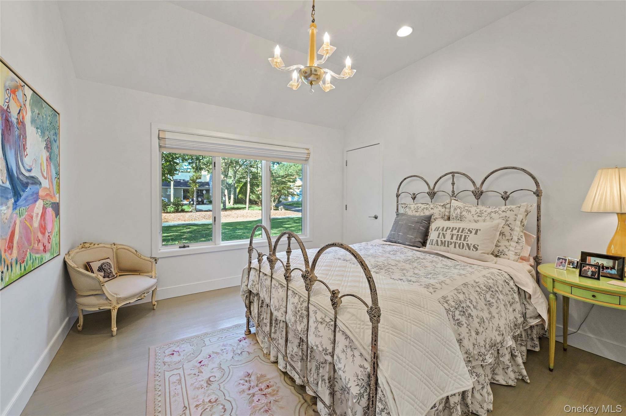 6 Bridle Path Westhampton Beach, NY 11978 - Photo 18 of 33 a bedroom with a bed and a chandelier