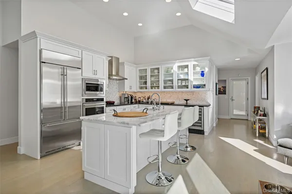 a kitchen that has a lot of cabinets a sink and appliances