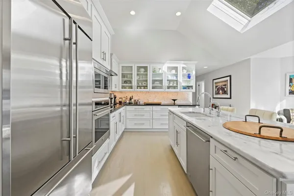 a kitchen with stainless steel appliances granite countertop a refrigerator and a sink