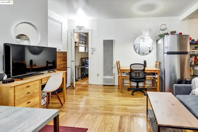 a living room with furniture a flat screen tv and kitchen view