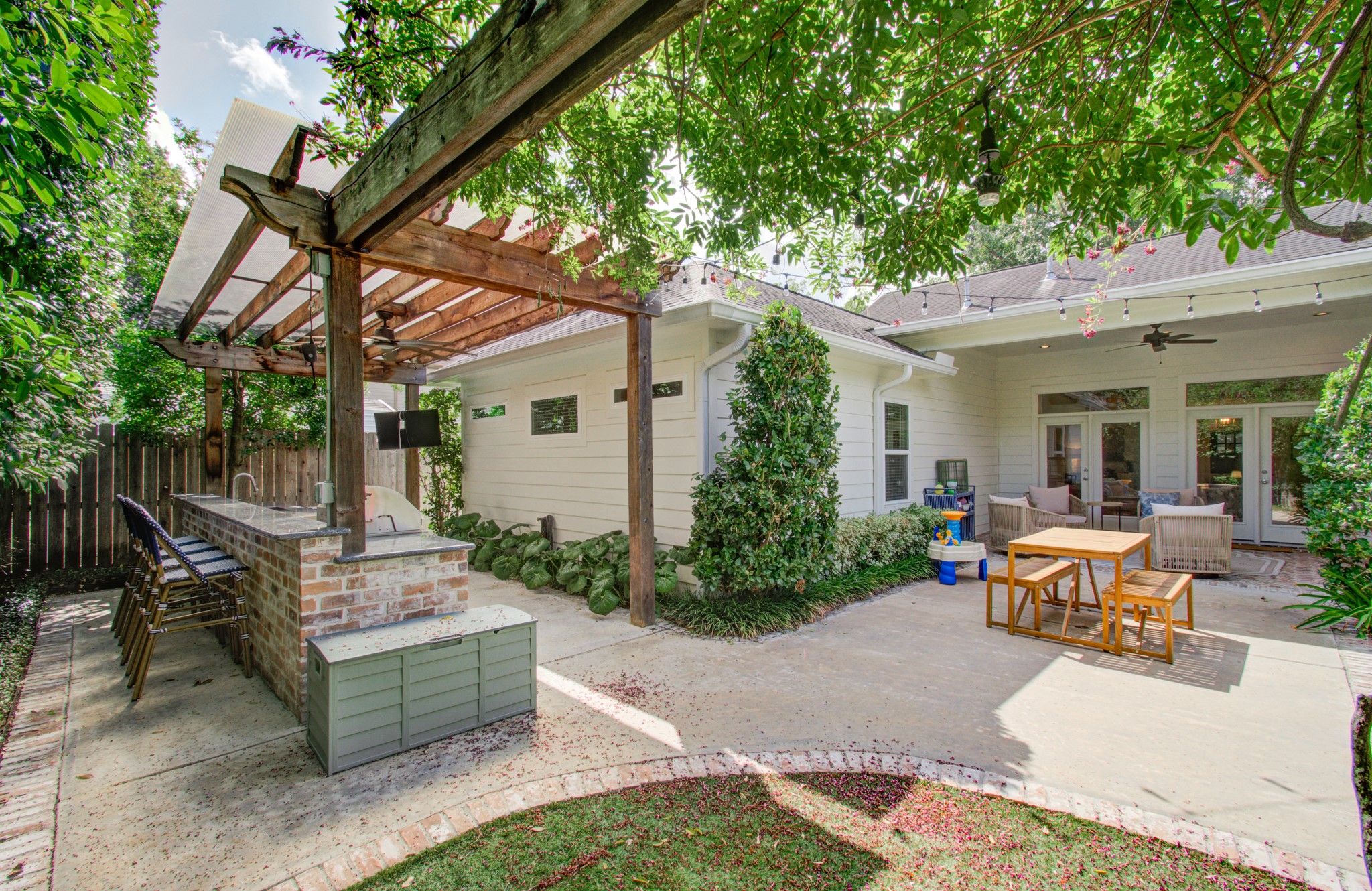 1722 Chippendale Road Houston, TX 77018 - Photo 34 of 41 Charming backyard oasis featuring a covered patio, outdoor kitchen with bar seating, and lush landscaping, perfect for entertaining and relaxation.