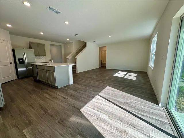 a kitchen with a sink stainless steel appliances counter top space and cabinets