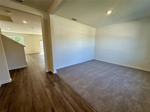 an empty room with wooden floor and a window