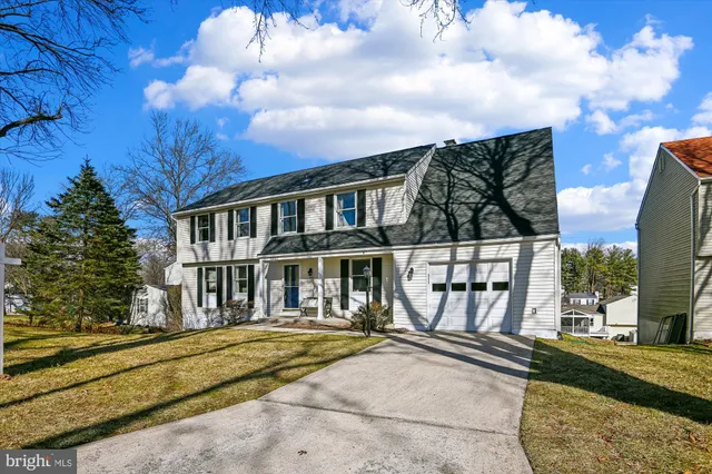 a view of a white house with large windows and a small yard