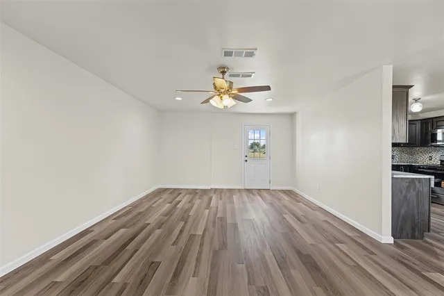 a view of wooden floor and a chandelier fan in a room