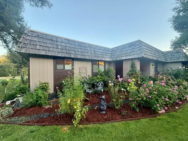 a view of a house with a yard and garden