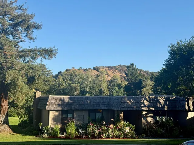 a kitchen with kitchen island granite countertop a stove top oven a sink a counter space and cabinets