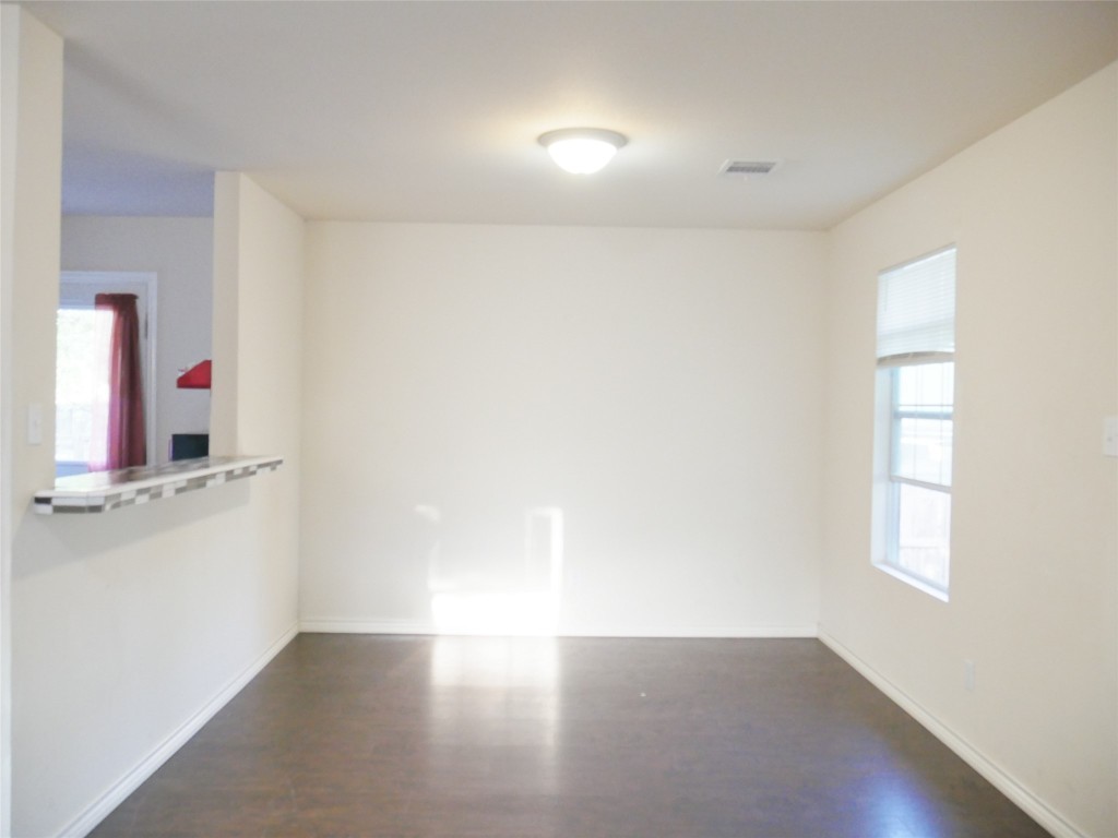 1013 Price Street Taylor, TX 76574 - Photo 5 of 12 a view of an empty room with wooden floor and a window