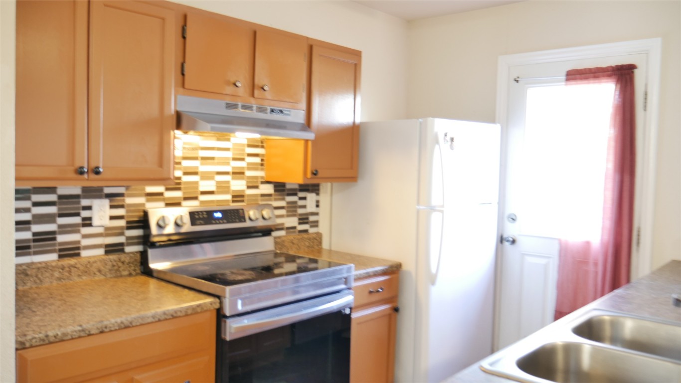 1013 Price Street Taylor, TX 76574 - Photo 6 of 12 a kitchen with a refrigerator and a sink