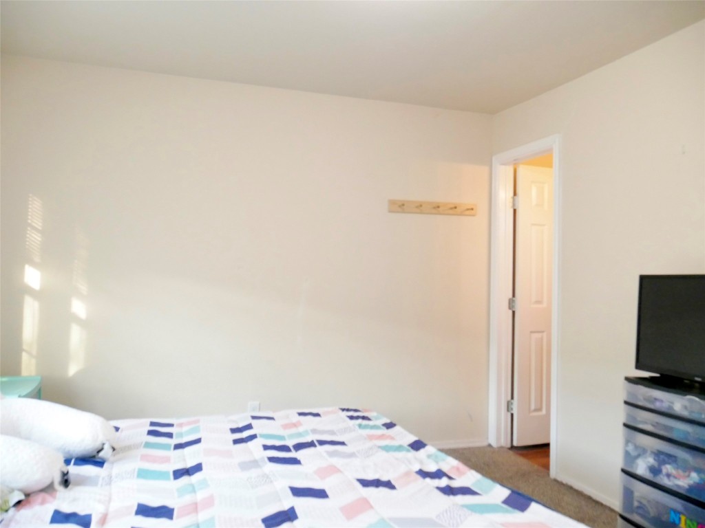 1013 Price Street Taylor, TX 76574 - Photo 7 of 12 a bedroom with a bed and a flat screen tv