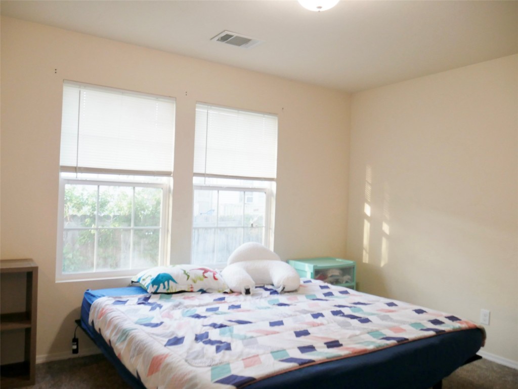 1013 Price Street Taylor, TX 76574 - Photo 9 of 12 a bedroom with a bed and wooden floor