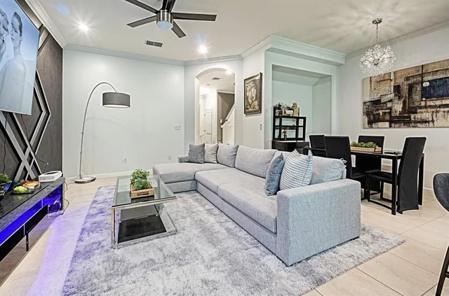 a living room with furniture a flat screen tv and a table