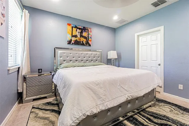 a bed sitting in a bedroom next to a window