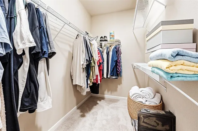 a view of walk in closet with clothes