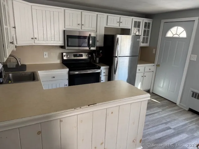 a kitchen with a refrigerator sink and cabinets