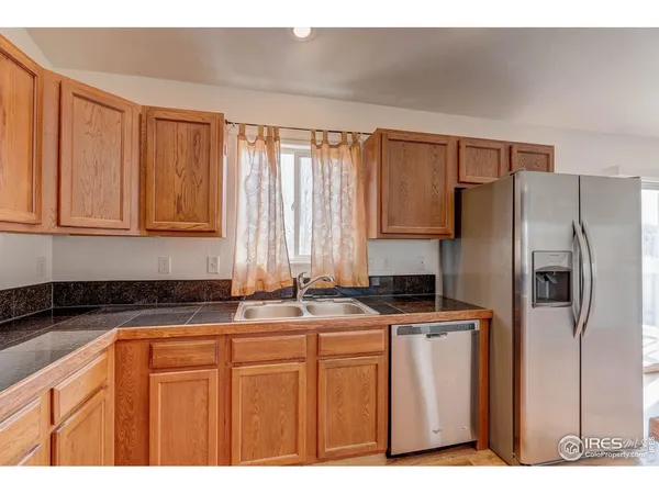 a kitchen with stainless steel appliances granite countertop a refrigerator a sink a stove and dishwasher