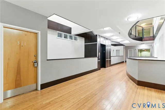 a view of a hallway with wooden floor and entryway