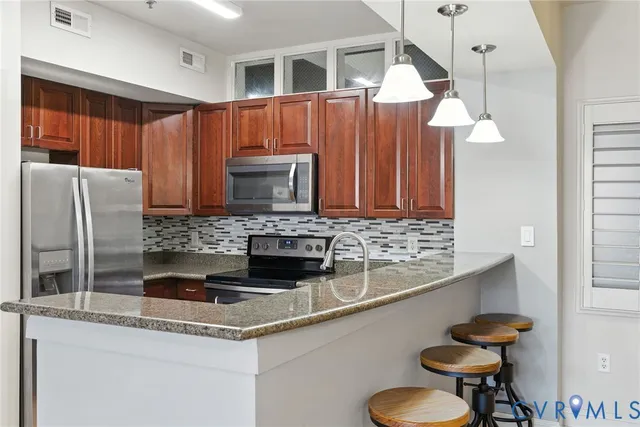 a kitchen with stainless steel appliances granite countertop a sink refrigerator and cabinets
