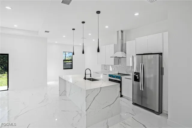 a kitchen with stainless steel appliances granite countertop a refrigerator and a sink