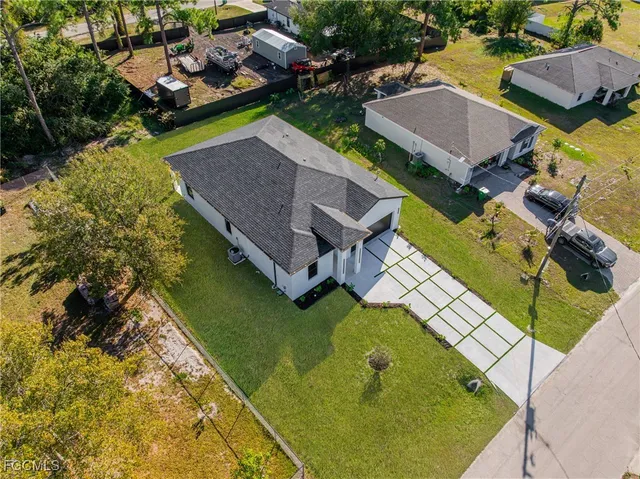 an aerial view of a house with swimming pool and outdoor seating