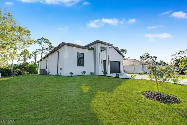 a view of a backyard with plants and large trees