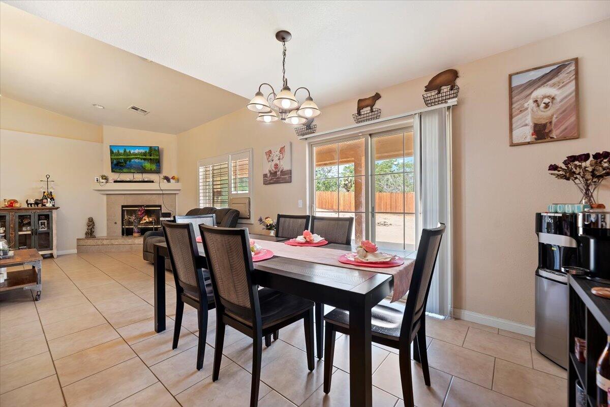 7562 Inca Trail Yucca Valley, CA 92284 - Photo 13 of 30 a dining room with furniture a rug and a chandelier