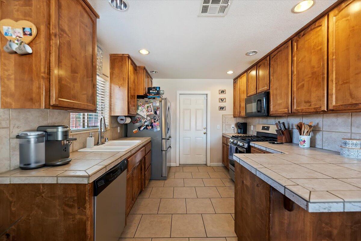 7562 Inca Trail Yucca Valley, CA 92284 - Photo 14 of 30 a kitchen with a sink stove top oven and cabinets