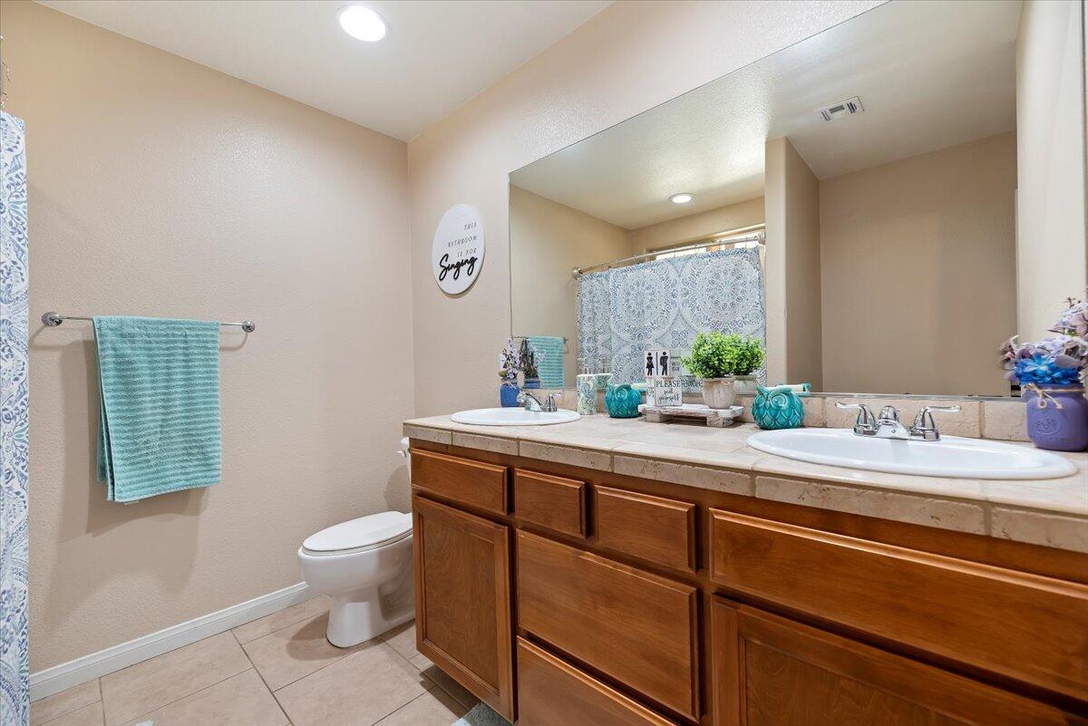 7562 Inca Trail Yucca Valley, CA 92284 - Photo 20 of 30 a bathroom with a granite countertop toilet sink and mirror