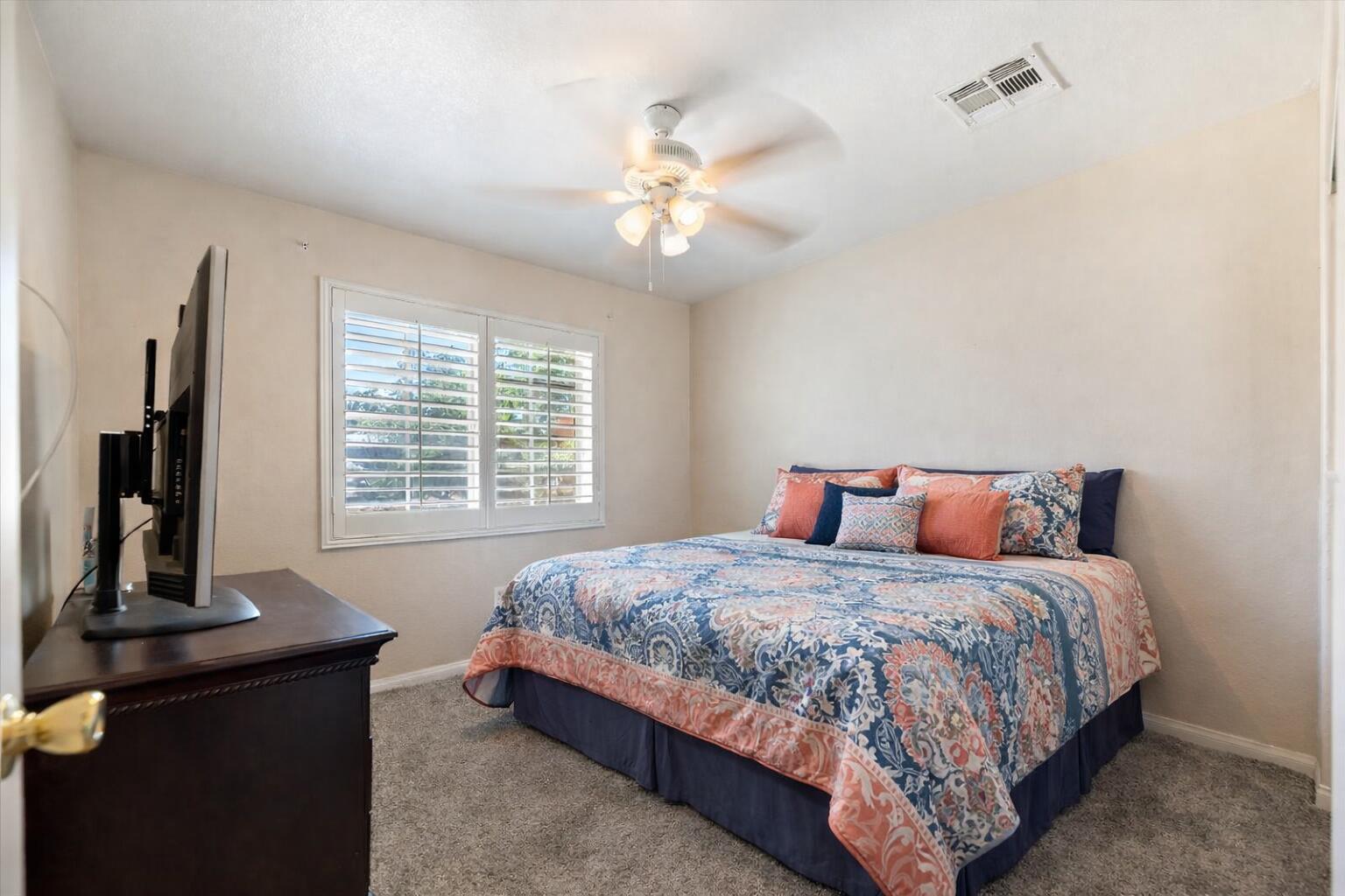 7562 Inca Trail Yucca Valley, CA 92284 - Photo 24 of 30 a bedroom with a bed and a chandelier