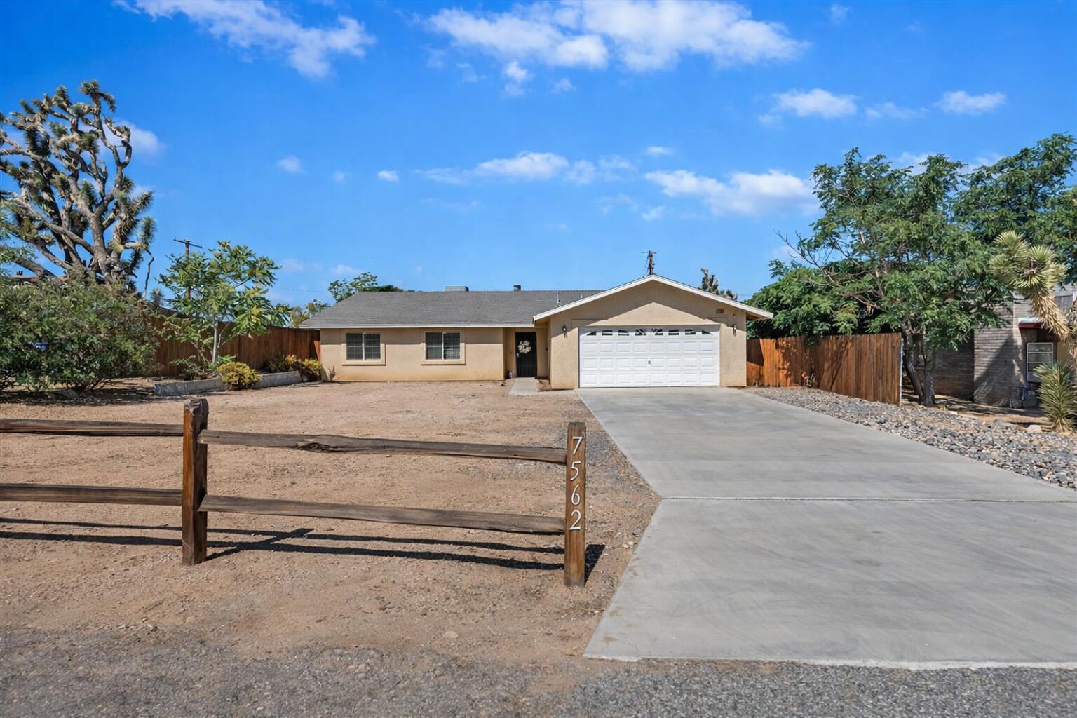 7562 Inca Trail Yucca Valley, CA 92284 - Photo 4 of 30 a front view of a house with a yard and garage