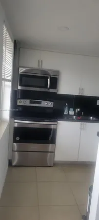a kitchen with white cabinets and a stove