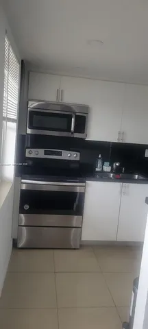a kitchen with white cabinets and a stove