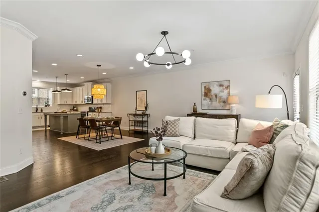 a living room with furniture kitchen and a chandelier