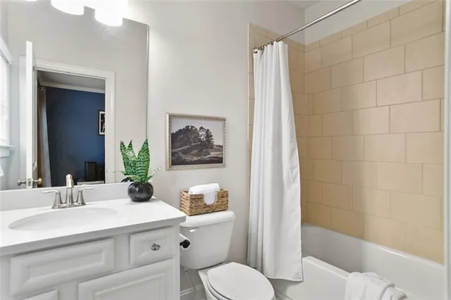 a bathroom with a sink a toilet a mirror and shower