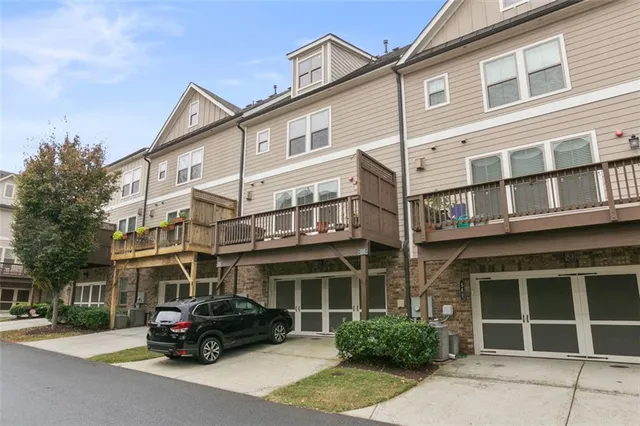 a front view of a house with a yard and potted plants