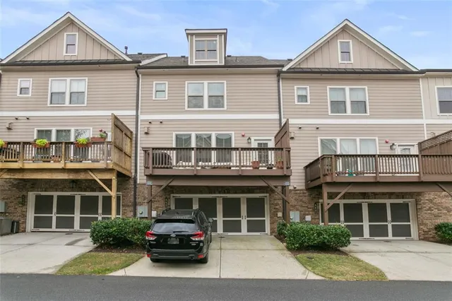a front view of a house with a yard and potted plants