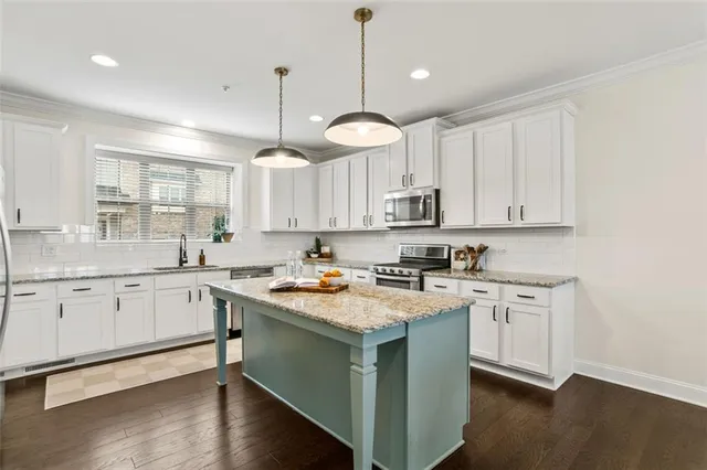 a kitchen with a white cabinets sink and stove