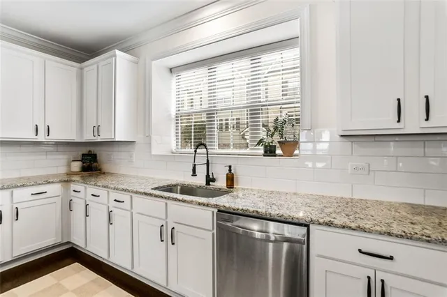 a kitchen with granite countertop white cabinets and white appliances