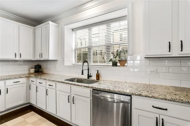 a kitchen with granite countertop white cabinets and white appliances