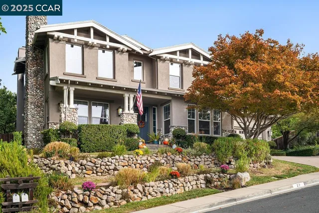a front view of a house with lots of flowers around