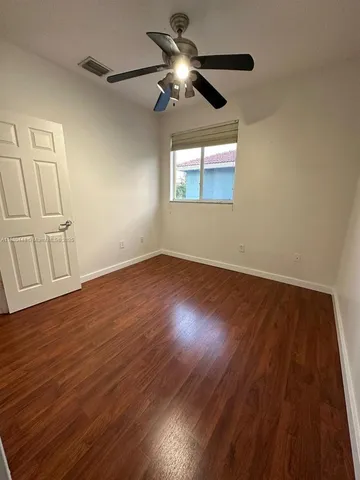 an empty room with wooden floor and entrance