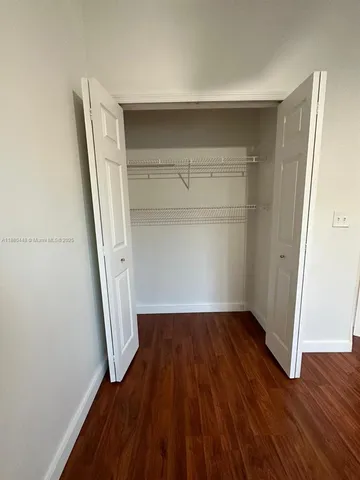 a view of walk in closet with wooden floor