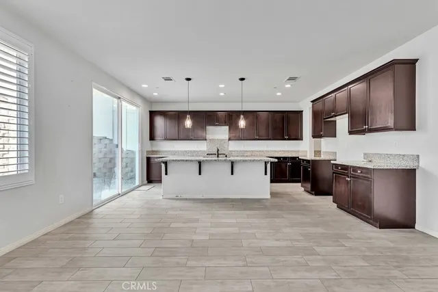 a kitchen with stainless steel appliances granite countertop a sink a stove a refrigerator and cabinets with wooden floor