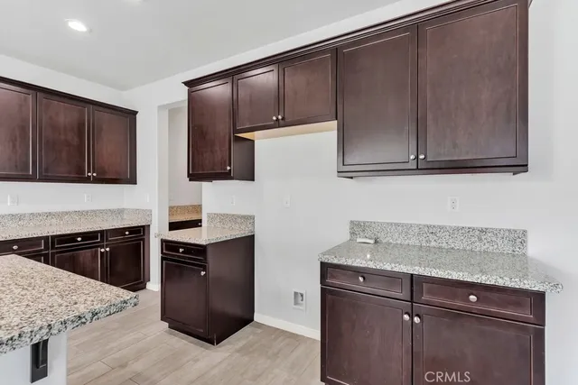 a kitchen with kitchen island granite countertop a sink a counter space appliances and cabinets