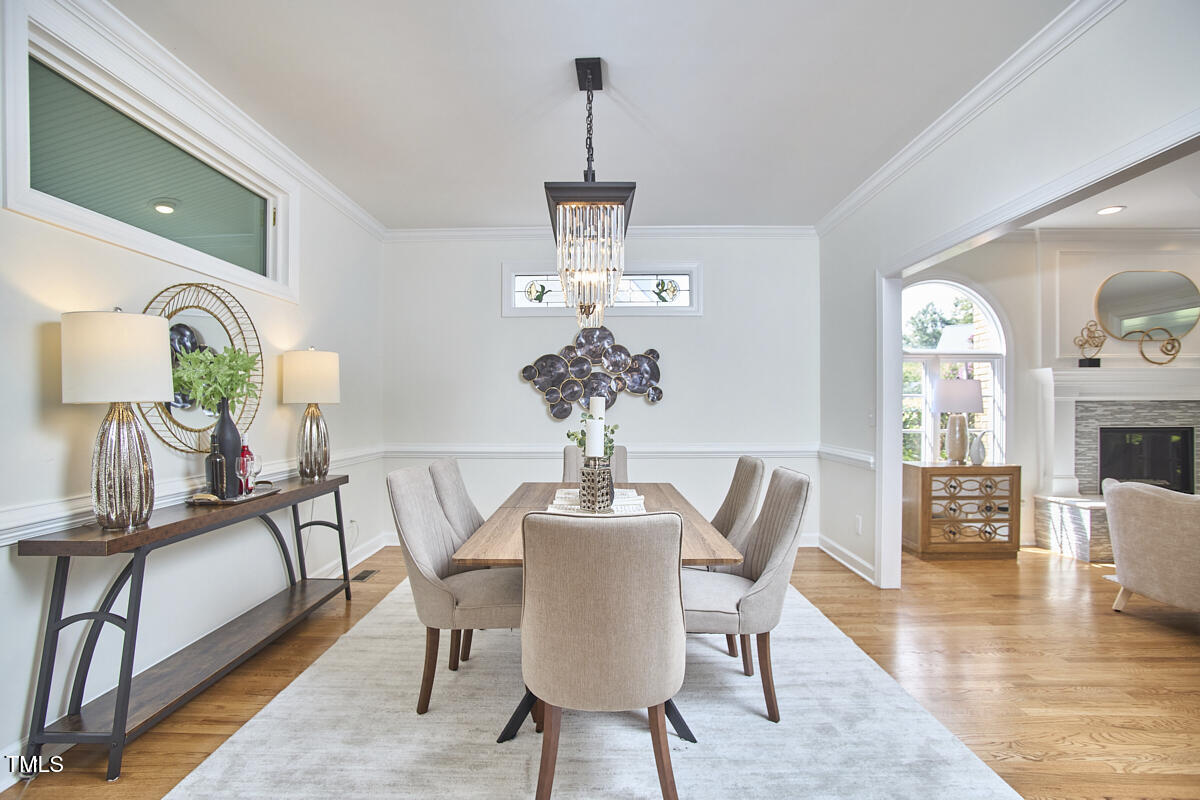 4303 Thetford Road Durham, NC 27707 - Photo 20 of 88 a dining room with furniture a chandelier and wooden floor