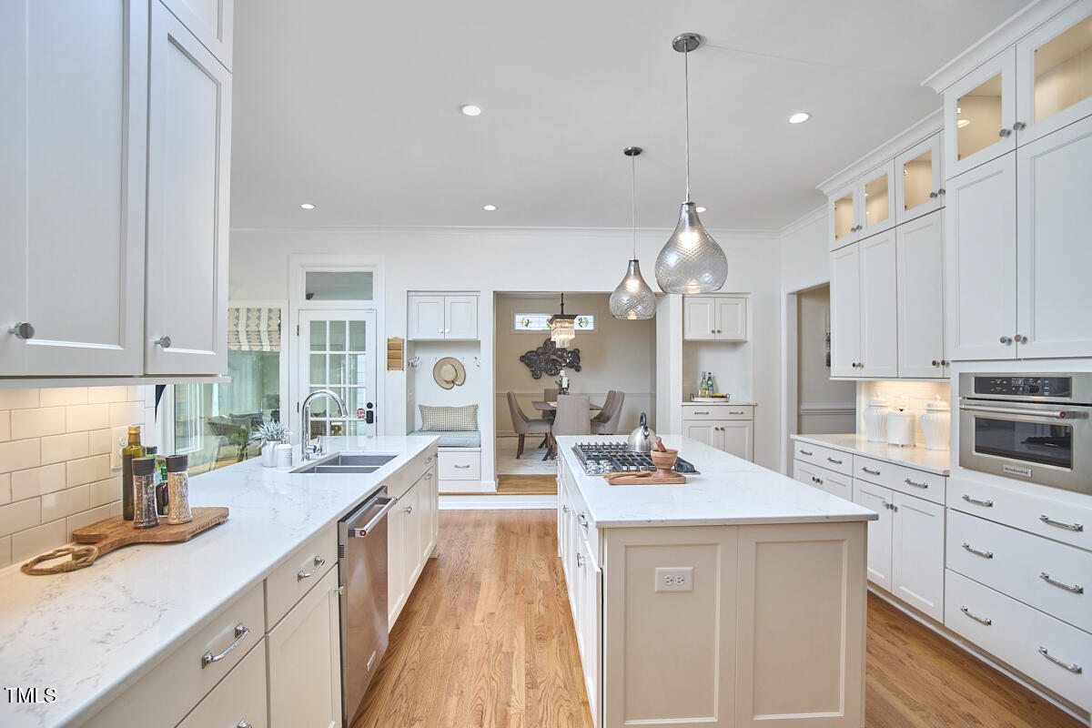 4303 Thetford Road Durham, NC 27707 - Photo 31 of 88 a large kitchen with kitchen island a large counter space a sink appliances and cabinets