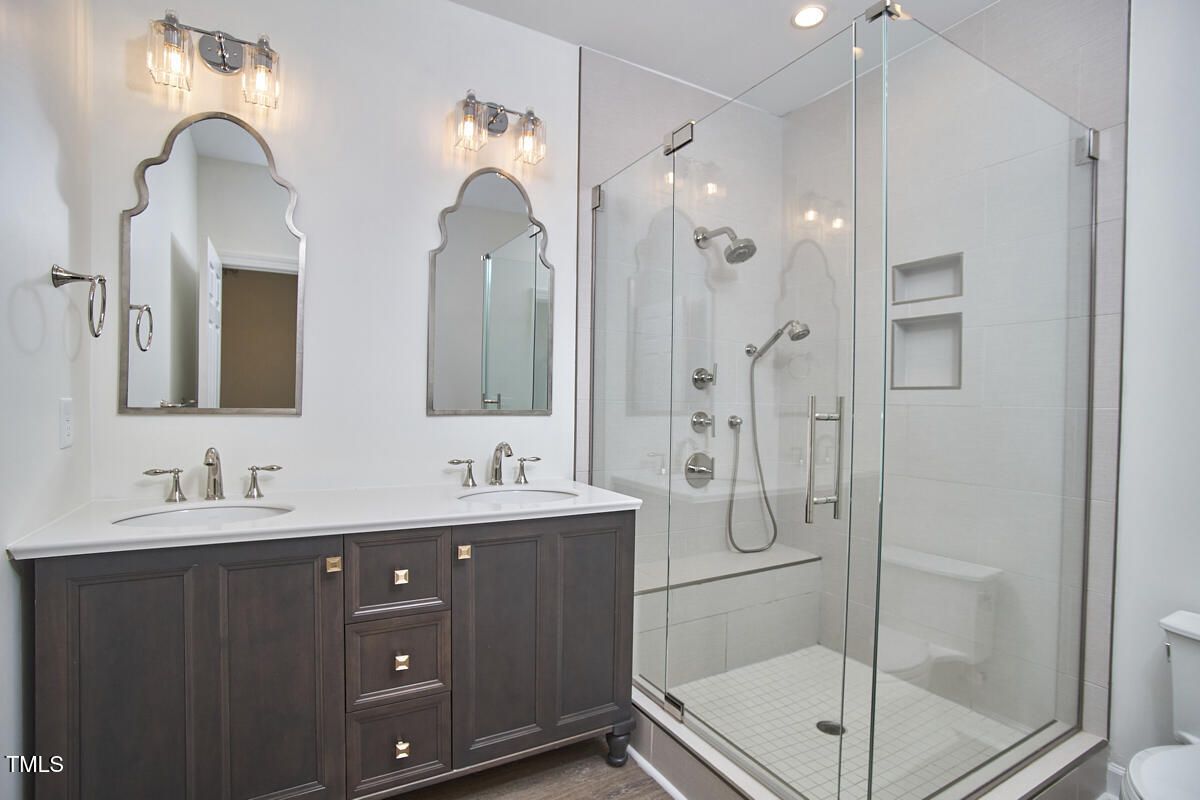 4303 Thetford Road Durham, NC 27707 - Photo 38 of 88 a bathroom with a double vanity sink mirror and shower