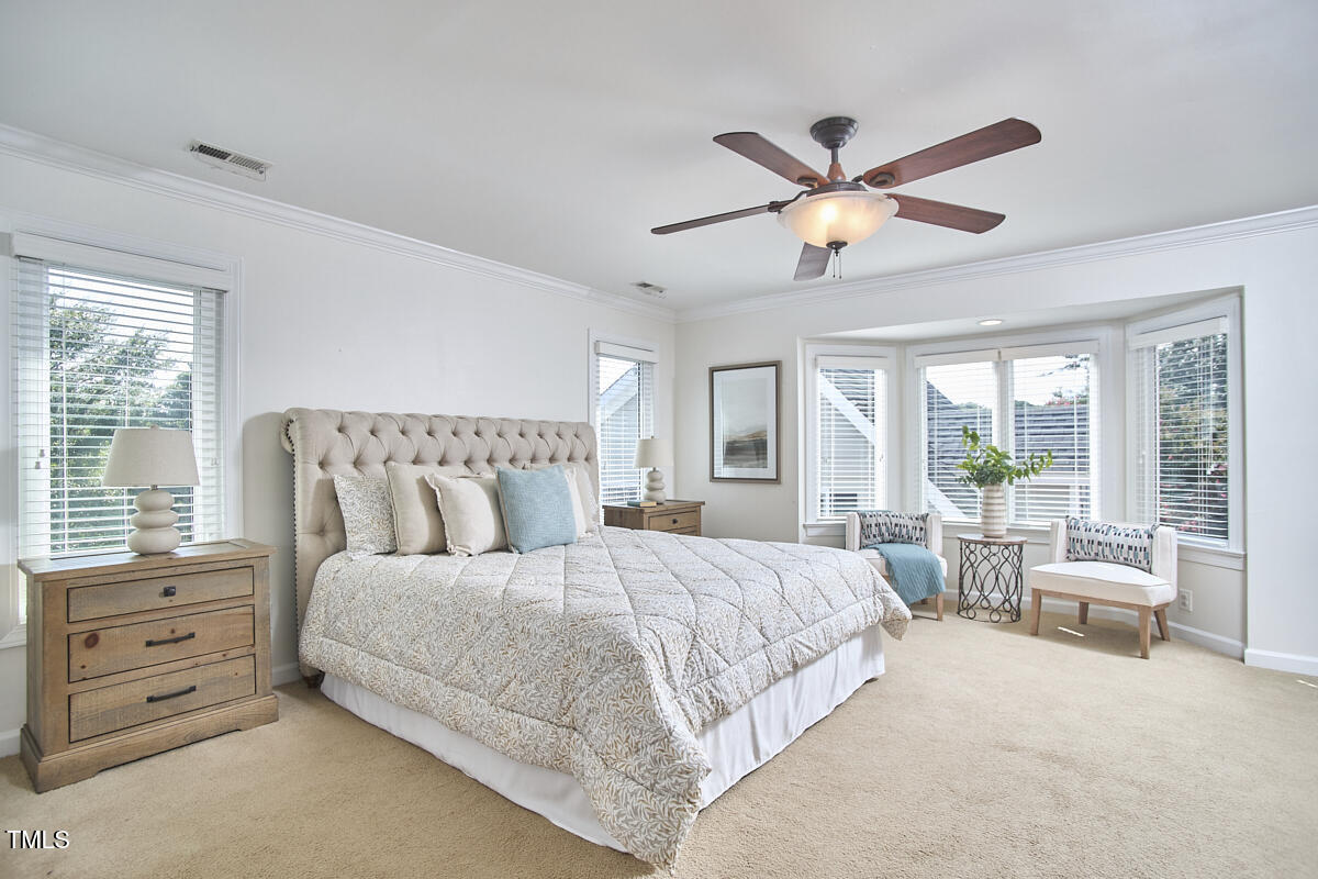 4303 Thetford Road Durham, NC 27707 - Photo 40 of 88 a bedroom with a large bed and a chandelier