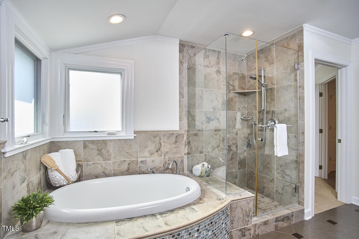 4303 Thetford Road Durham, NC 27707 - Photo 47 of 88 a bathroom with a tub shower and mirror