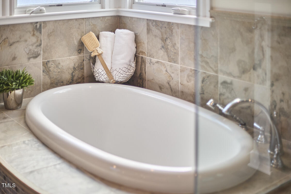 4303 Thetford Road Durham, NC 27707 - Photo 48 of 88 a white bath tub sitting in a bathroom